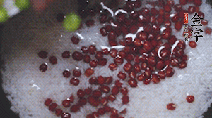 將炒好的食材和大米、紅豆一起放進(jìn)電飯鍋煮。