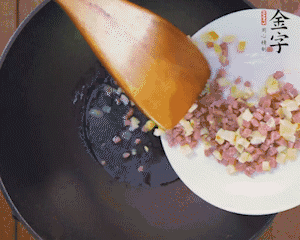 油溫3成熱時(shí)，下火腿丁、筍丁炒出香味，放豌豆粒翻炒均勻2分鐘。