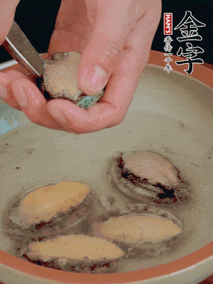 鮑魚加鹽、清水浸泡，用勺子挖出鮑魚肉。