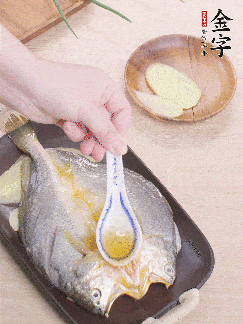 盤(pán)底鋪姜片，放黃魚(yú)，淋2勺料酒。