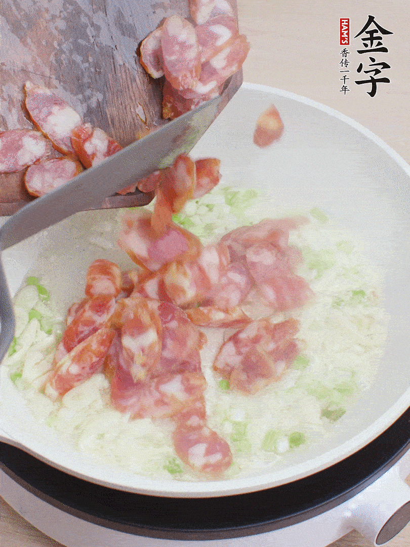 油5成熱，蒜末、蔥白爆香，下香腸炒出香味。