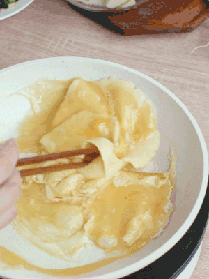 油6成熱時(shí)，下雞蛋液，邊緣凝固時(shí)翻拌成塊狀。