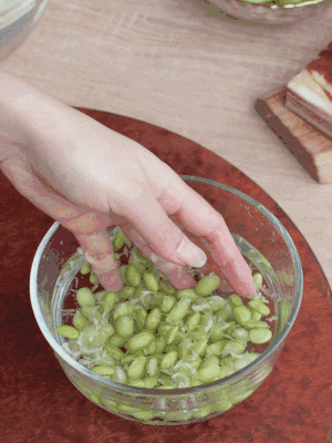 青豆剝殼，搓去外衣。