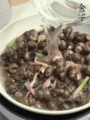 倒處理干凈的螺螄翻炒，加3勺料酒。加清水蓋過螺螄，中火蓋蓋煮5分鐘。