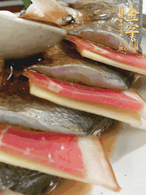 魚肚中塞蔥結(jié)、火腿片，魚身上碼放姜片、火腿片，倒入混合的料汁。