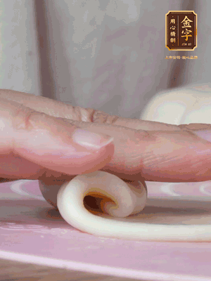 做面劑 油皮按扁，中間包入一個(gè)油酥，邊緣收緊捏死。包好的面劑按扁，用搟面杖搟壓成橢圓形。從底部向上卷成筒狀，用保鮮膜蓋好松弛15分鐘，再把筒狀縱向搟壓成長條狀。再卷一次，松弛20分鐘