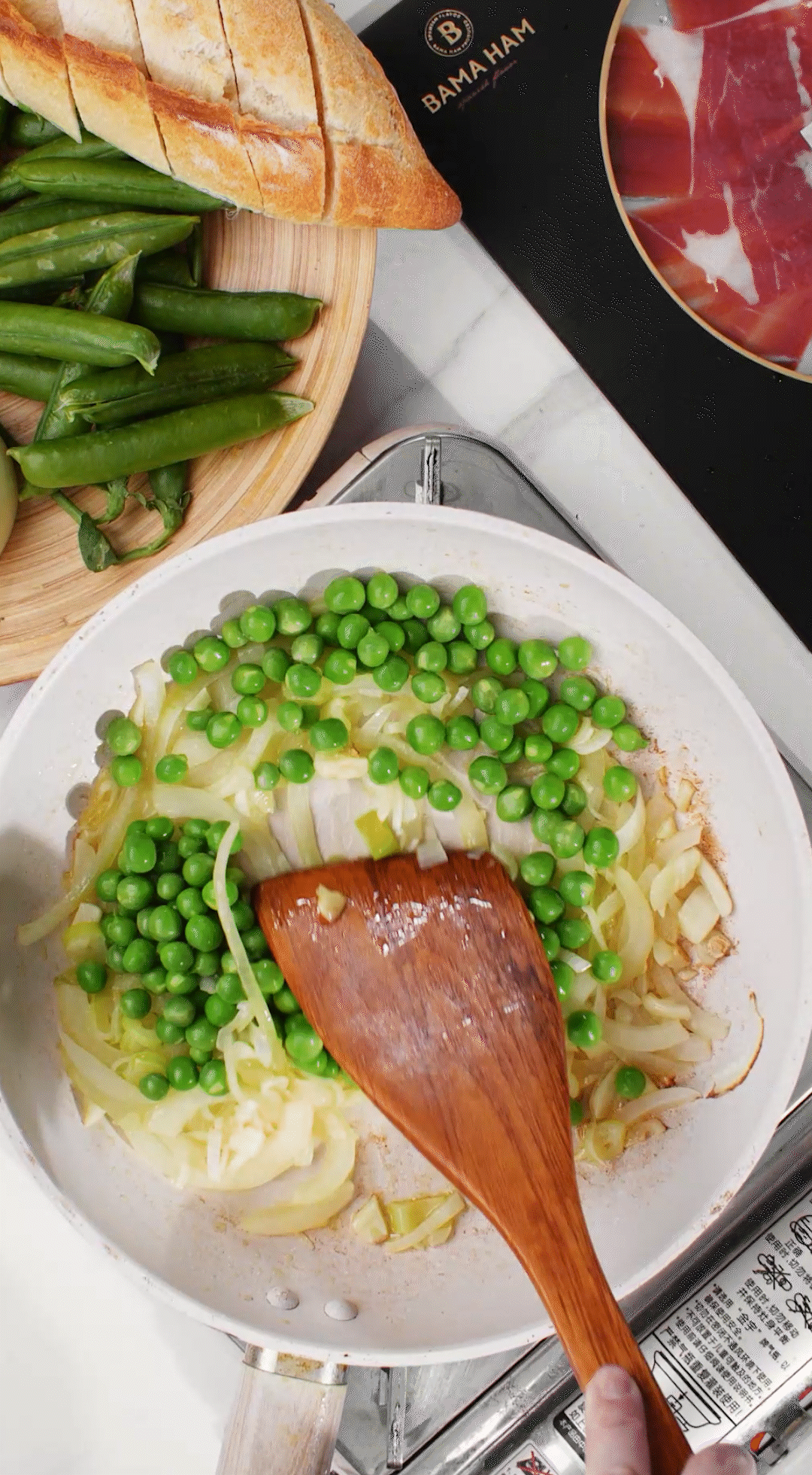 鍋中放入黃油融化，加入洋蔥絲、大蔥蔥白絲、蒜末翻炒變軟出香味。加入剛剛汆燙冰鎮(zhèn)后的豌豆，取出一點(diǎn)點(diǎn)待會擺盤裝飾用。加一點(diǎn)鹽 (和黑胡椒) 調(diào)味。