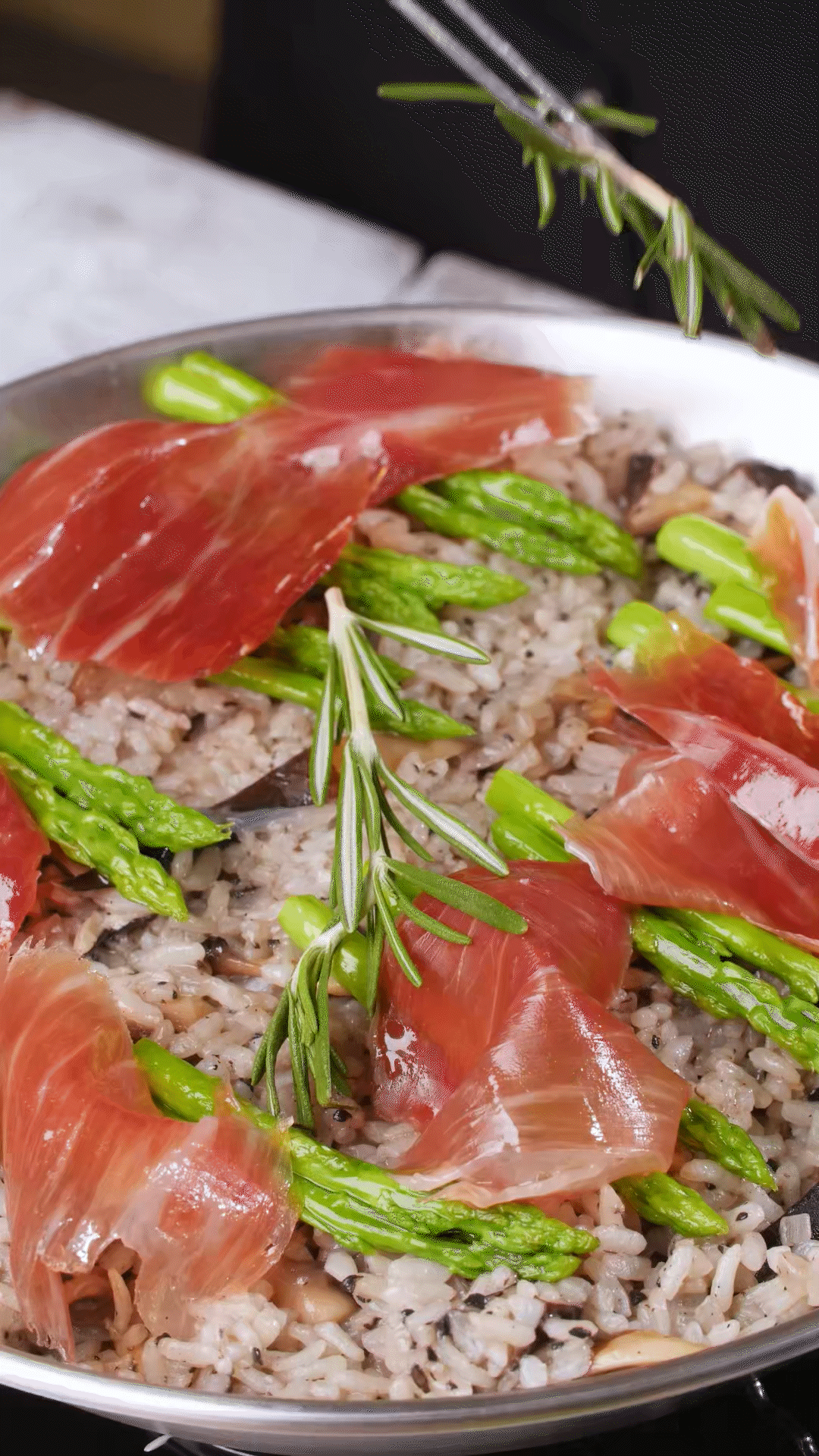 放上巴瑪火腿和蘆筍、點(diǎn)綴迷迭香、三色堇