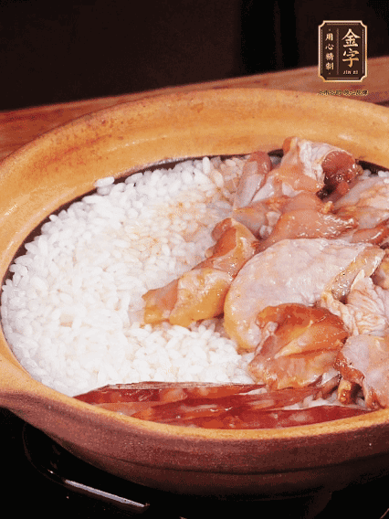 煮到椰子水微微收干轉(zhuǎn)小火，快速均勻鋪上雞肉、金字香腸